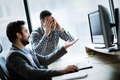 employees looking at computer and discussing business continuity plan